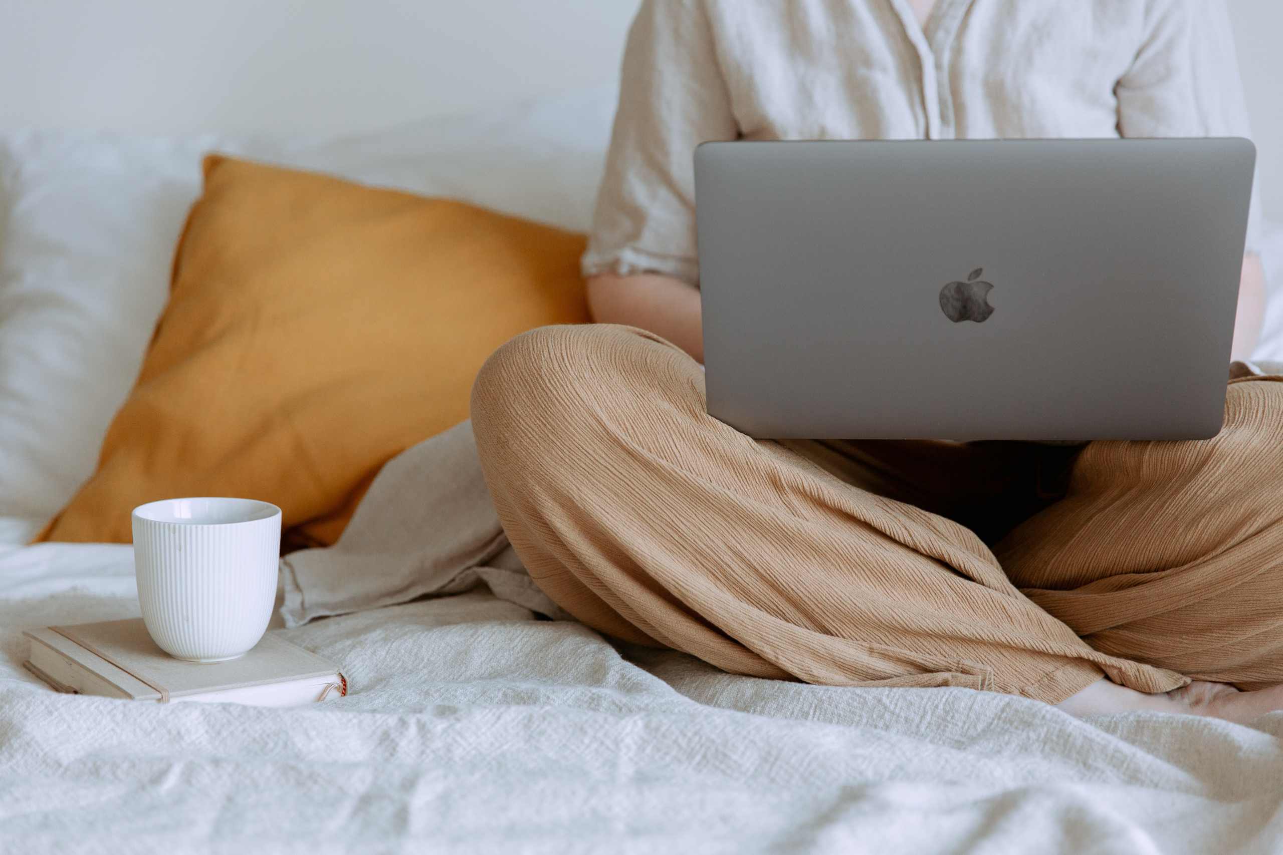 Person Sitting on a Bed with a Laptop