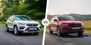 A comparison of a white SEAT Ateca and a red Skoda Karoq. The SEAT Ateca is driving on a road surrounded by trees, and the Skoda Karoq is driving on a road surrounded by hills. The two cars are separated by the word "VS.