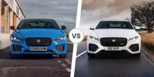 A side-by-side comparison of two Jaguar cars. The car on the left is blue and has a sportier design with larger wheels and a more aggressive front bumper. The car on the right is white and has a more elegant design with smaller wheels and a less aggressive front bumper.