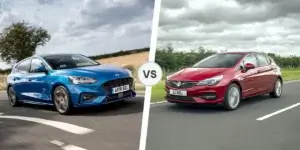 A side-by-side comparison of two cars. On the left is a blue Ford Focus, and on the right is a red Vauxhall Astra. Both cars are driving on a road with a scenic landscape in the background.