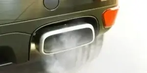 Close-up of a car's exhaust tailpipe, showing the metallic end of the exhaust system with slight discoloration around the edges. The tailpipe is part of the vehicle's emissions system, where exhaust gases are released.