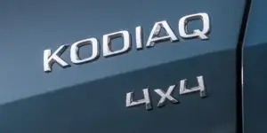 A close-up photo of the "KODIAQ" and "4x4" badges on the side of a car. The badges are chrome-plated and have a black background.