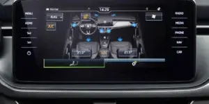 A close-up of a car's touchscreen display. The display shows the car's interior layout with controls for the seats, climate control, and other functions. The time is displayed as 14:29, and the temperature is set to 21.5 degrees Celsius.