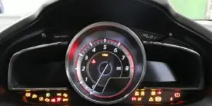 Car dashboard with speedometer indicating 3 mph, tachometer at 0 RPM, and various warning lights illuminated, including check engine, tire pressure, and battery