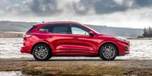 A red Ford Kuga parked on a lakeside.