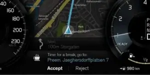 A car's digital dashboard showing a map with a route highlighted, a speedometer reading 230 km/h, a gear selector in the "D" position, and various other controls and information.